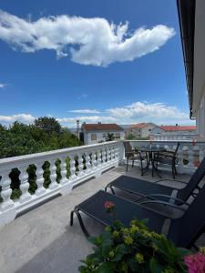balcón con mesa, sillas y barandilla blanca en Apartments Ostojic, en Krk