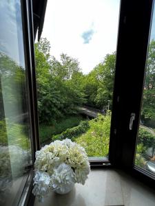 un vase de fleurs blanches assis sur un rebord de fenêtre dans l'établissement Villa Limburg, à Leipzig