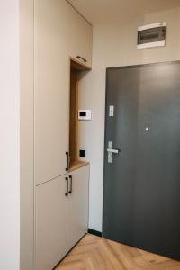 a kitchen with a door and a refrigerator at Arra Apartments in Cluj-Napoca
