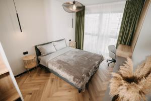 een slaapkamer met een bed en een raam bij Arra Apartments in Cluj-Napoca