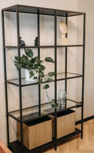 a black book shelf with a plant in it at Arra Apartments in Cluj-Napoca