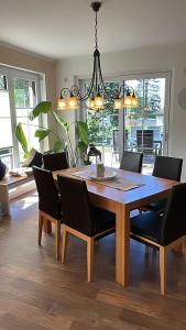 een eetkamer met een houten tafel en stoelen bij Ferienwohnung "Am Hochufer" in Göhren