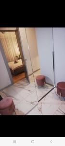 a room with a bed and two stools and a mirror at NEW BIG LOFT APARTMENTS JURMALA with FREE SECURED PARKING in Jūrmala