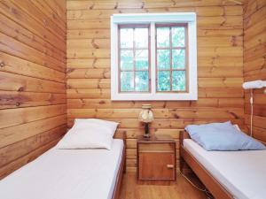 two beds in a room with wooden walls and a window at 5 person holiday home in Vejby-By Traum in Vejby
