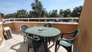 d'une table et de chaises vertes sur un balcon dans l'établissement ACV - Bahia Park-1ª linea planta 2 frontal, à Oropesa del Mar