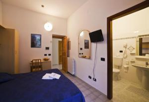 イスキアにあるHotel Riva del Soleのベッドとバスルーム付きのホテルルームです。