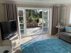 a living room with a flat screen tv and a couch at The Lodge in Birchington