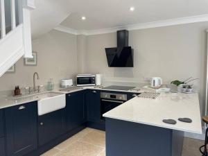 a kitchen with blue cabinets and a white counter top at The Lodge in Birchington