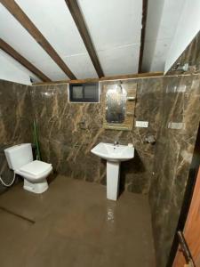 a bathroom with a toilet and a sink at Garden Oasis with 1 Bedroom & 1 Bathroom in Batticaloa