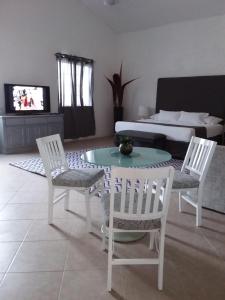 sala de estar con mesa, sillas y sofá en Junior suite Privada 7 min del Aeropuerto en Cancún