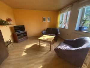 ein Wohnzimmer mit einem Sofa und einem Couchtisch in der Unterkunft Ferienwohnung in Schleswig-Holstein, Hohn in Hohn