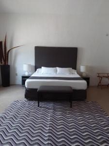 1 dormitorio con 1 cama grande con alfombra en Junior suite Privada 7 min del Aeropuerto en Cancún