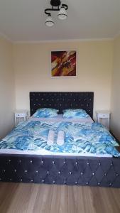 a bed with blue comforter and blue pillows at Apartament Estera in Oradea