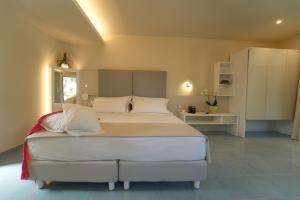 a bedroom with a large bed in a room at Hotel Village Eden in Capo Vaticano