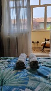 a bed with towels on top of it with a window at Apartament Estera in Oradea