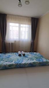 a bed with two towels on it in front of a window at Apartament Estera in Oradea
