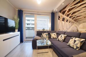 a living room with a couch and a tv at Apartament Dobra Energia Kołobrzeg in Kołobrzeg