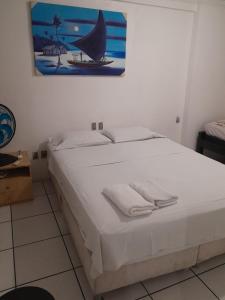 1 dormitorio con 1 cama blanca grande y toallas. en Residence Porto de Iracema, en Fortaleza