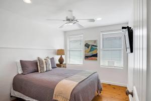 a bedroom with a bed and a ceiling fan at Classy 4BDRM Home W/Pool Mins To Beach and Shops! in Port Aransas