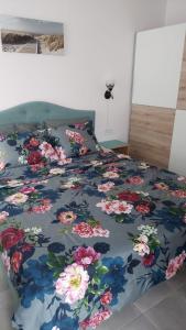 Una cama con un edredón azul con flores. en Anthic 7 Apartment 3 en Sozopol