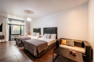 1 dormitorio con 2 camas y sofá en 5411 Soho Hotel en Buenos Aires