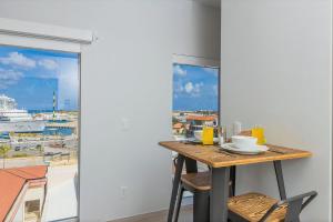 a kitchen with a table and a view of a harbor at Fully Smart Studio Apartment Harbor View in Oranjestad