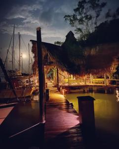 a dock with a building with a dock at Tortugal Boutique River Lodge in Rio Dulce