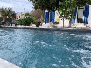 una piscina di acqua blu di fronte a una casa di Villa Egiza con piscina e accesso diretto al mare a Carini