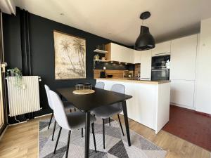 a black and white kitchen with a table and chairs at Résidence de l'Hermitage, T2 avec Parking in Le Touquet-Paris-Plage