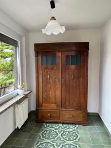 a large wooden cabinet in a room with a window at Am Schusterberg in Schielo