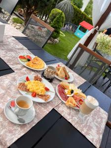 a table with plates of breakfast food and a cup of coffee at Ivian Family Hotel in Ravda