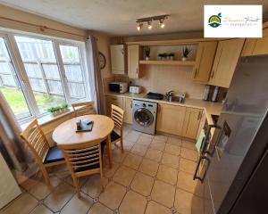 a kitchen with a table and chairs and a table and a refrigerator at 3 Bedroom House at Low rate- near Coventry City Centre with Wi-fi Netflix Unlimited, driveway parking by Passion Fruit Properties- 16RWC in Coventry