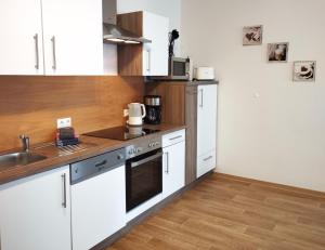 a kitchen with white cabinets and a sink at Ferienwohnung Berger in Reinhardtsdorf +20 photos