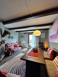 een woonkamer met een bank en een tafel bij giomein, appartamento di charme artistico ,CIR 0279 in Breuil-Cervinia