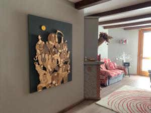 uma sala de estar com uma parede de arte em madeira na parede em giomein, appartamento di charme artistico ,CIR 0279 em Breuil-Cervinia
