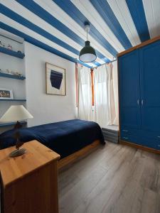 een slaapkamer met een blauw en wit gestreept plafond bij giomein, appartamento di charme artistico ,CIR 0279 in Breuil-Cervinia
