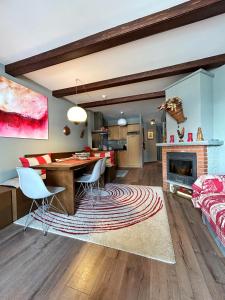 uma cozinha e sala de estar com uma mesa e uma lareira em giomein, appartamento di charme artistico ,CIR 0279 em Breuil-Cervinia