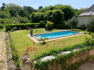 a garden with a swimming pool in a yard at Le Petit Vigneau in Ménil