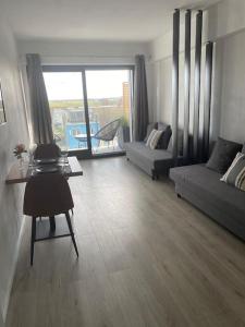 ein Wohnzimmer mit einem Sofa und einem Tisch in der Unterkunft Nieuwe studio Westende Edelweiss in Middelkerke