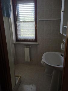 baño con lavabo y aseo y ventana en Villa Mori, en Gradoli