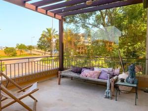 a porch with a couch and a swing at White shell vilamoura in Maritenda