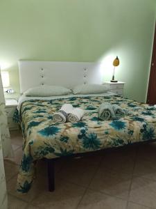 een slaapkamer met een bed met een bloemenbed bij B&B Kazakova in Domusnovas