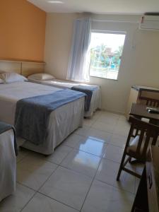 um quarto de hotel com duas camas e uma janela em Porto Carleto Temporadas - Quarto no Portobello Park Hotel em Porto Seguro