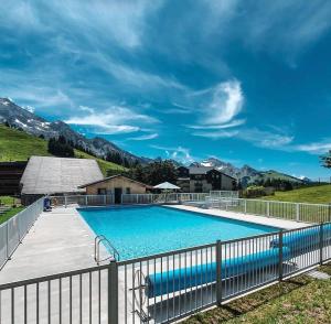 una gran piscina con una valla alrededor en Le lodge by Lilou en Manigod