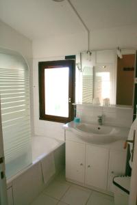 uma casa de banho com uma banheira, um lavatório e um espelho. em Hôtel Valentin em Les Deux Alpes