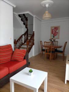 een woonkamer met een rode bank en een tafel bij Piso Sol in Laxe