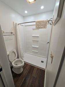 a small bathroom with a toilet and a shower at Oak Mar Motel in Oakland