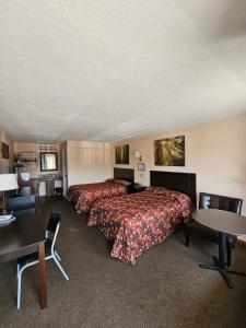 a hotel room with two beds and a table at Oak Mar Motel in Oakland