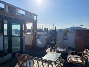 un patio con sillas y mesas en un balcón en Charming studio shared rooftop terrace/Jacuzzi 360 view, en Budapest
