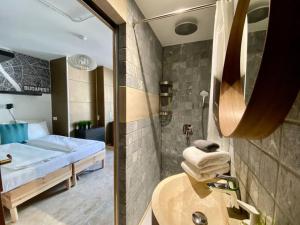 Habitación con baño con cama y lavabo. en Charming studio shared rooftop terrace/Jacuzzi 360 view, en Budapest